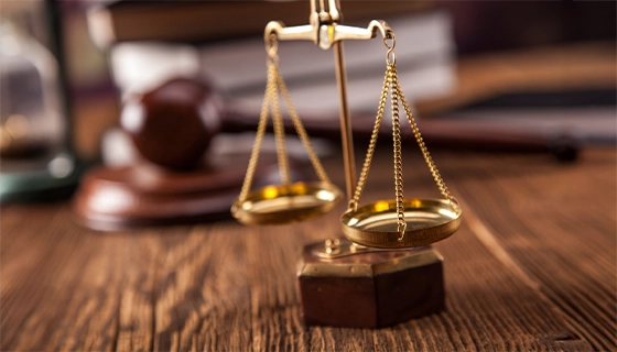 Scales Of Justice On Wooden Desk